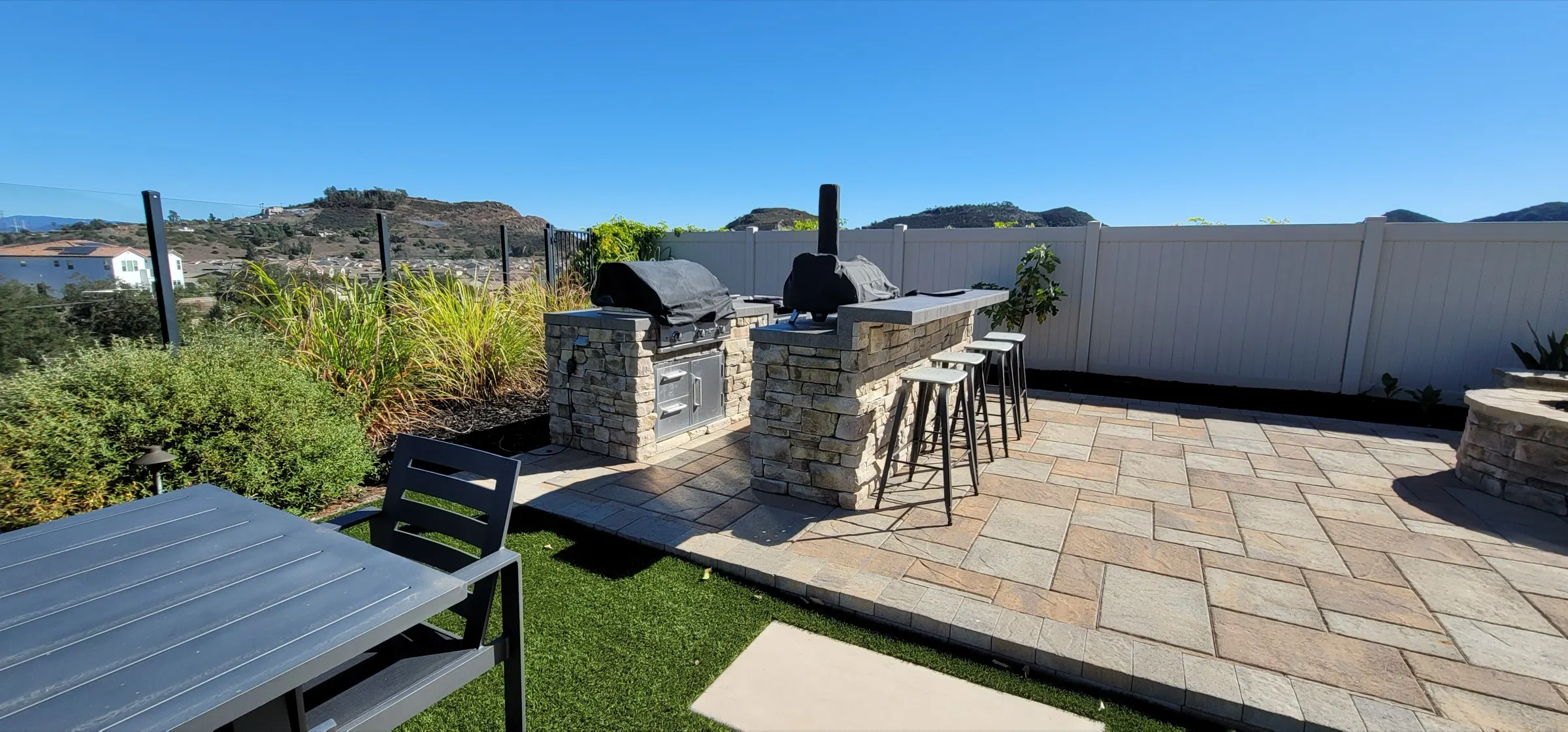 Hillside outdoor living area with turf and hardscape