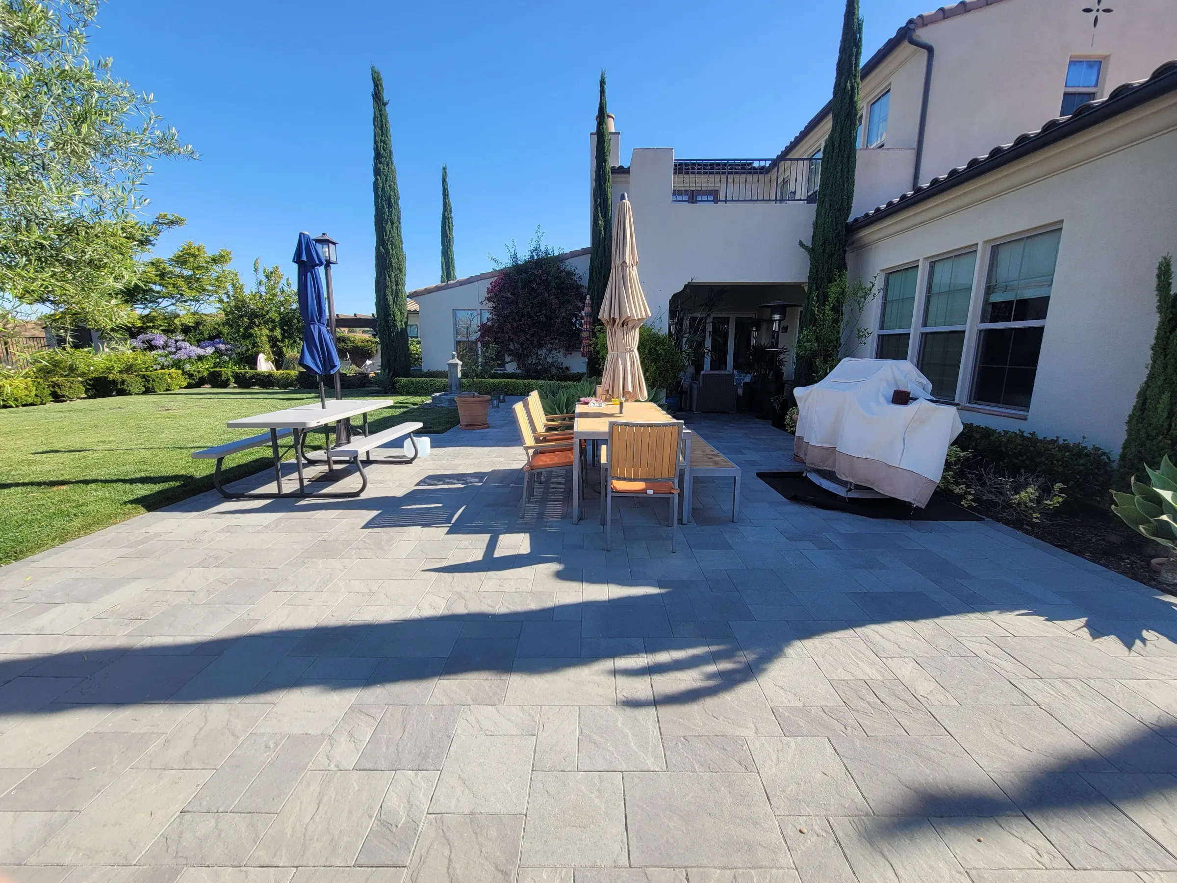 Open lawn and outdoor gathering space bordered by landscape planting