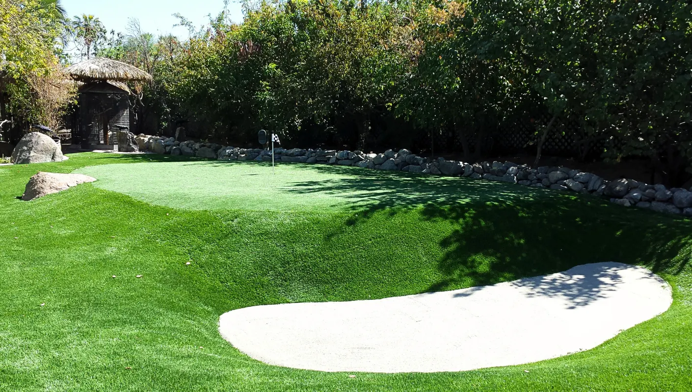 Large custom putting green in a landscaped yard